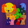 Colorful dog-shaped puzzle with numbered pieces on a purple background