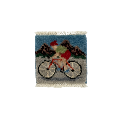 Small woven rug with a cyclist design on a white background