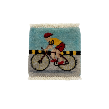 Knotted rug with a cyclist design on a white background