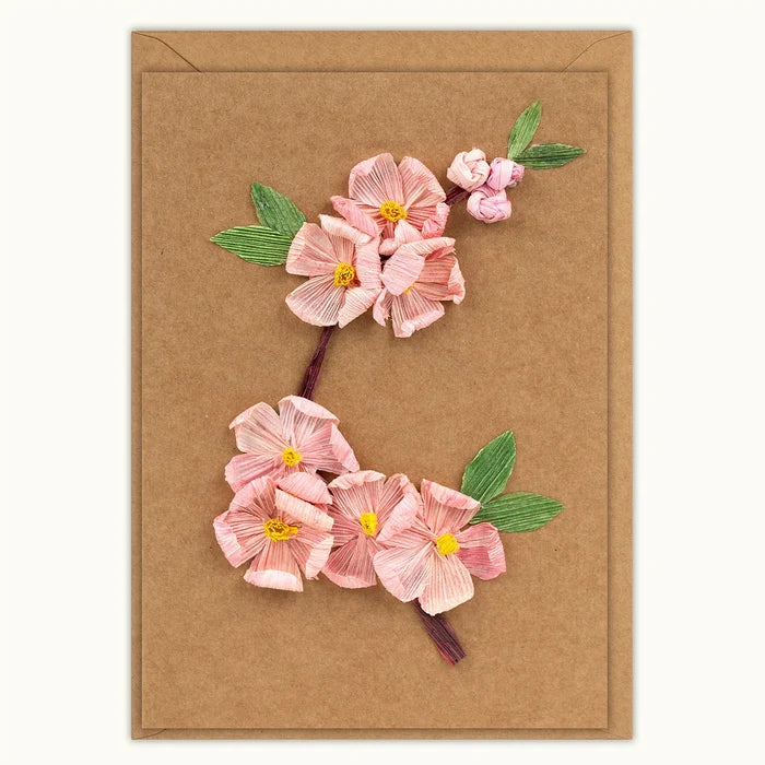 A rectangular kraft paper card featuring a raised, dimensional floral design of pink blossoms with green leaves and yellow centers on a brown kraft background.