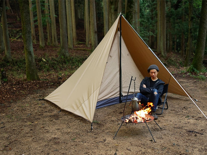 Chimaki Tent: beige and tan A-frame canvas tent with black poles in forest clearing