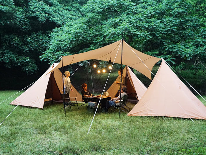 Chimaki Tent: beige canvas with black poles in grassy forest clearing