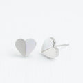 A pair of silver heart-shaped earrings on a white background.