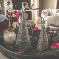 Handmade wire trees with silver wires and a star on top displayed with other Christmas decorations