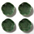 Four green ceramic leaf-patterned plates on a white background