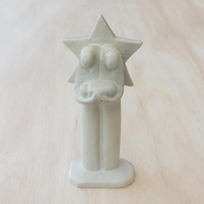 Hand carved white nativity scene with a star behind Mary and Joseph.