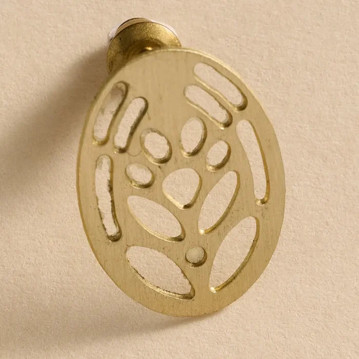 Gold decorative wall hook with a leaf pattern on a beige background