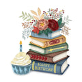 Stack of books with a 'Happy Birthday' message, cupcake, and floral arrangement on a white background
