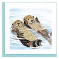 Quilled design of two otters in water with a light blue border