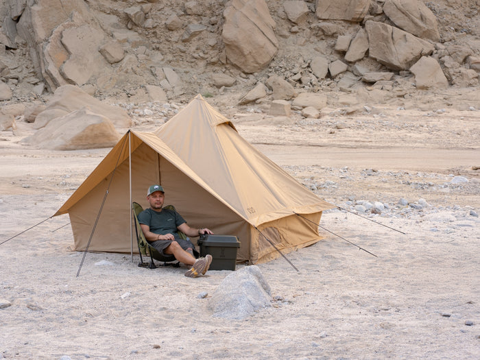 Tan Shonen Tent Canvo bell tent with guy lines and seated man