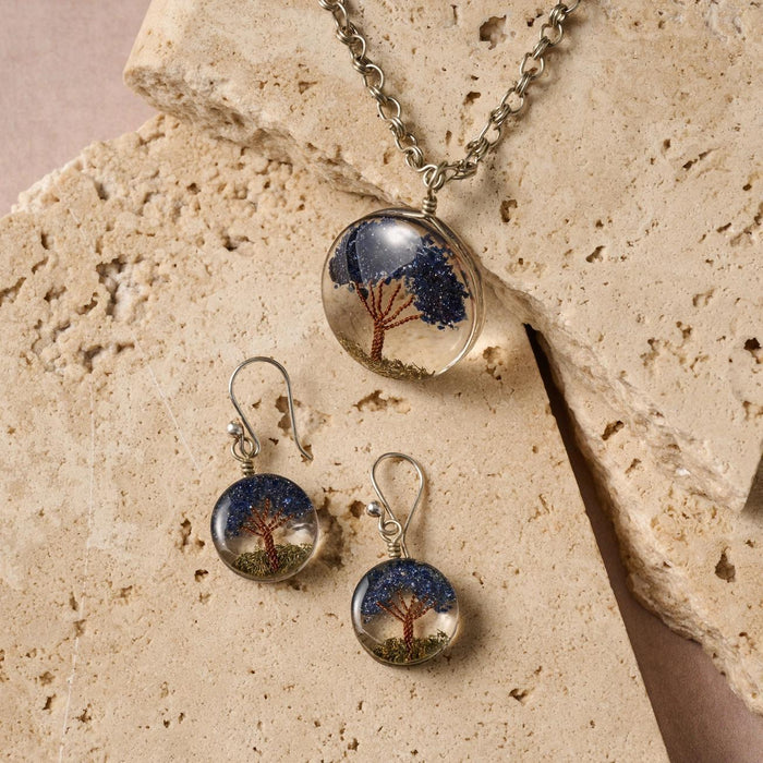 Tree of Life jewelry set with tree design on a beige stone surface
